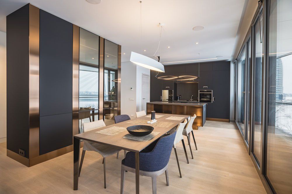 moderni iekārtota virtuve ar melniem krēsliem un koka galdu