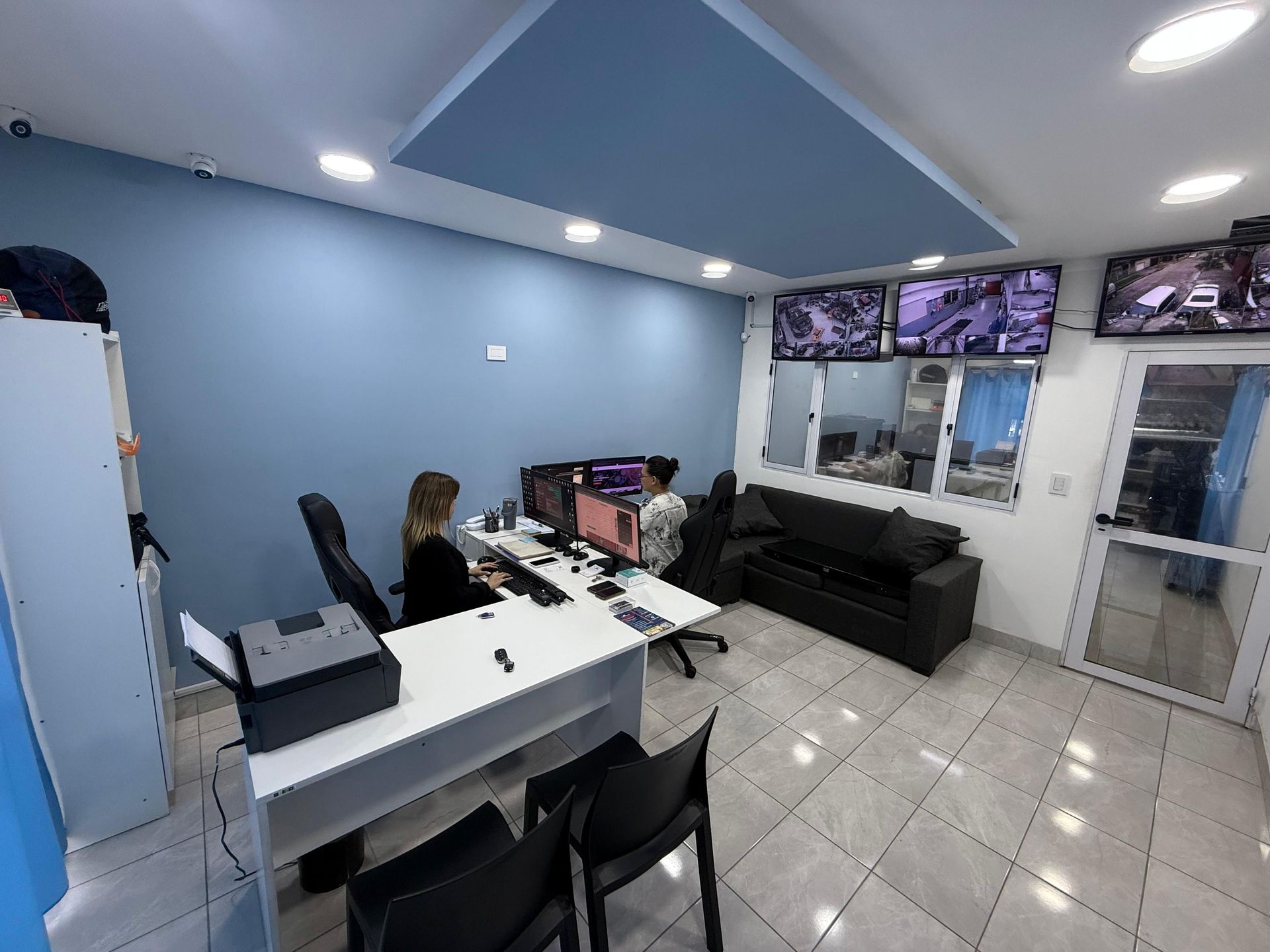 Un grupo de personas están sentadas en escritorios en una oficina.