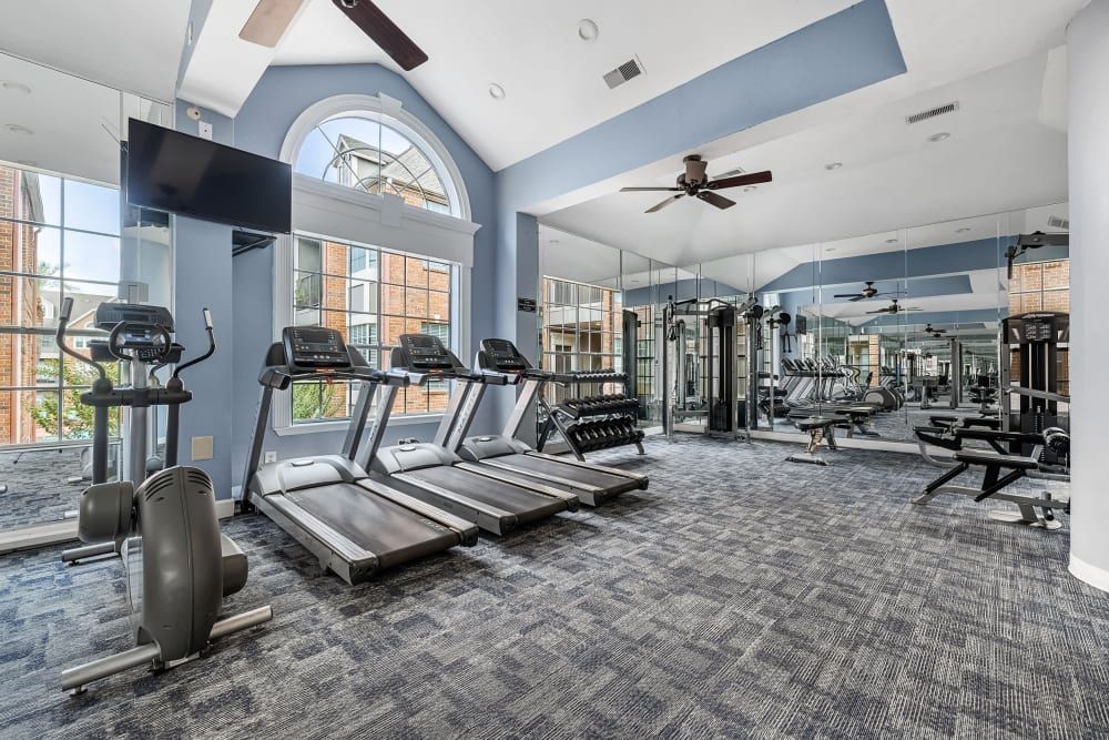 a large gym with a lot of treadmills and exercise equipment at Marquis on Pin Oak in Houston, TX.