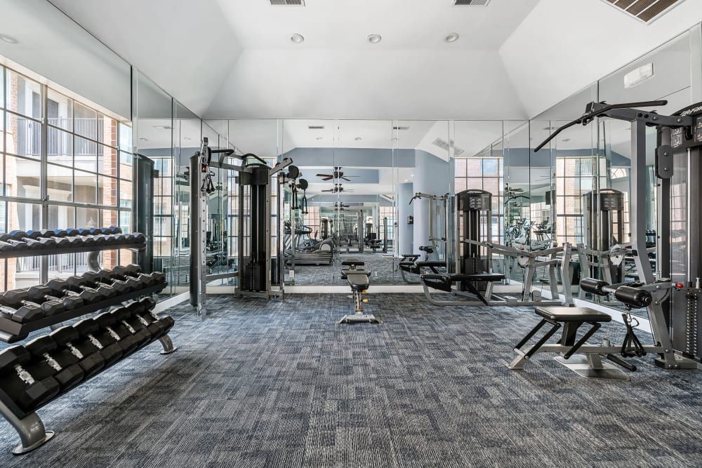 a large gym with a lot of equipment and a lot of mirrors at Marquis on Pin Oak in Houston, TX.