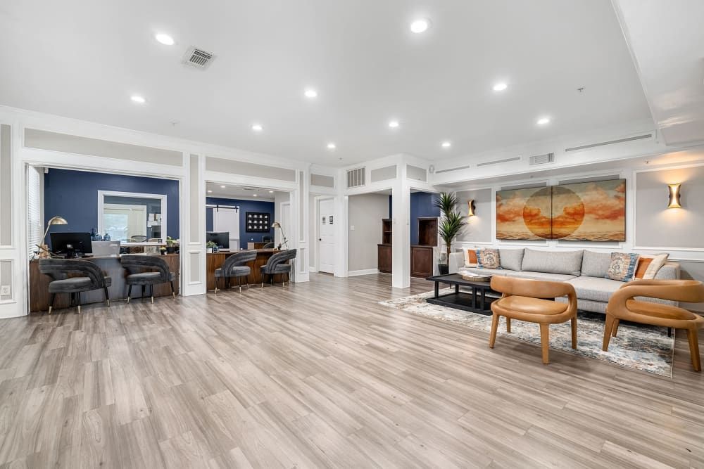 a large living room with hardwood floors, a couch, chairs, and a desk at Marquis on Pin Oak in Houston, TX.