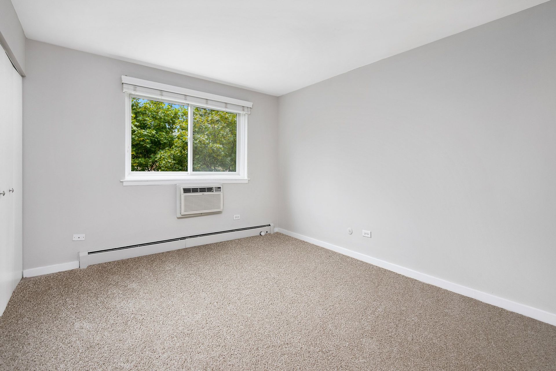 an empty room with carpet and a window