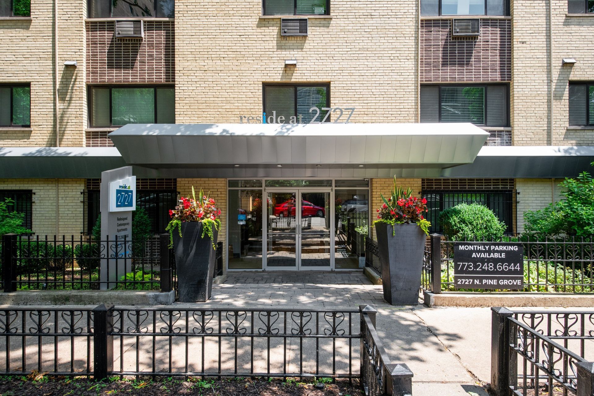 Outside of the building of Reside at 2727 showing the front doors and sidewalk