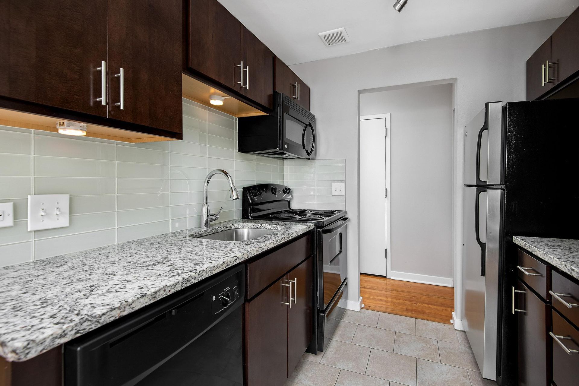 a kitchen with granite counter tops and black appliances