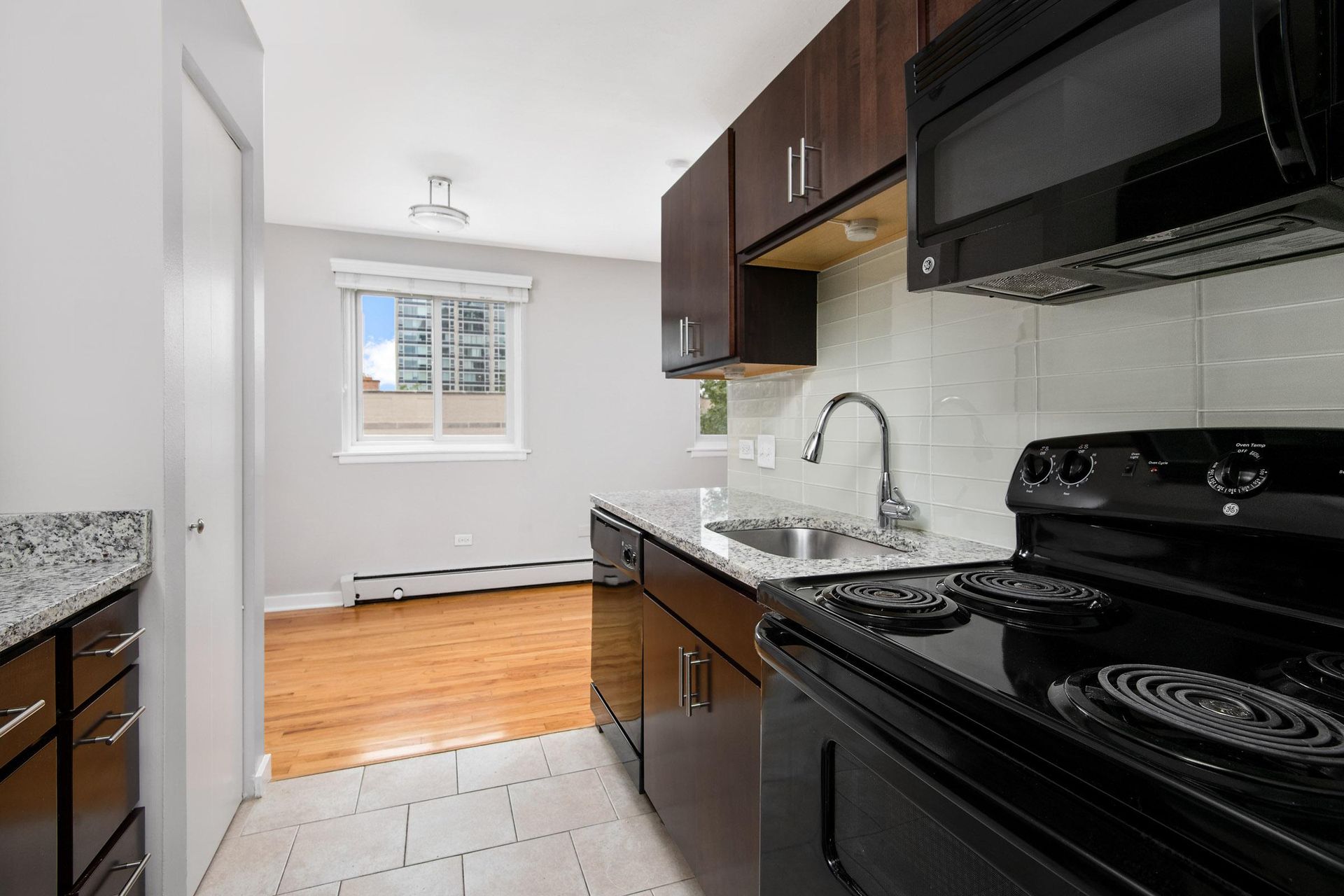 a kitchen with granite counter tops, brown cabinets and black appliances