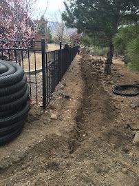 A fence is being built in a yard next to a pile of tires.