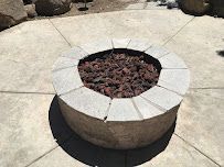 A fire pit is sitting on top of a concrete patio.