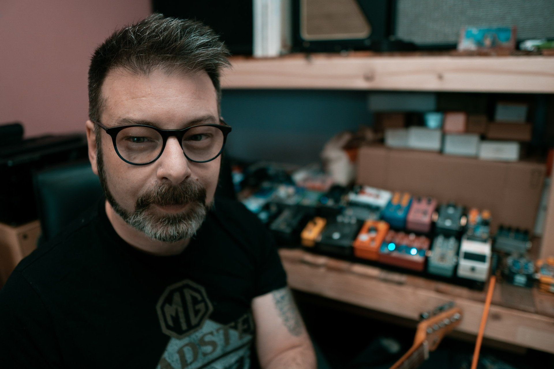 man with beard and glasses smirking at the camera