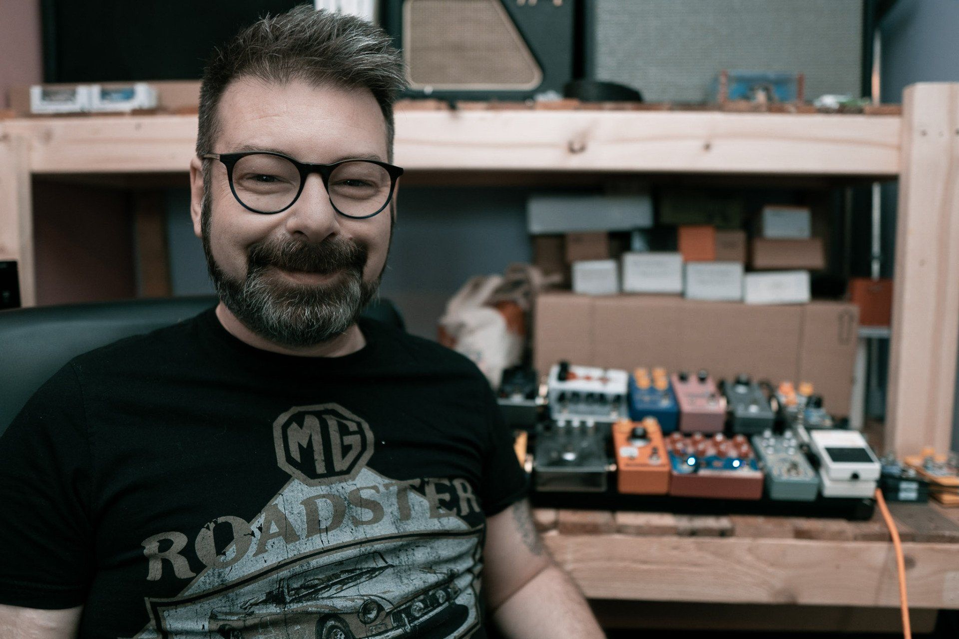 Michael emmergy fx smiling at the camera with effects pedals in the background