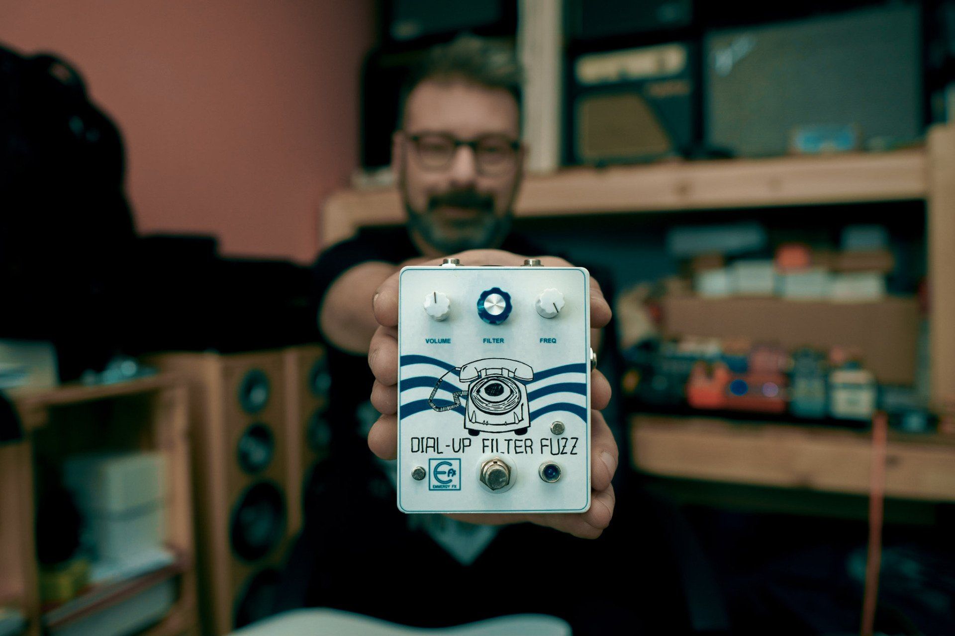 man with beard and glasses holding guitar peda