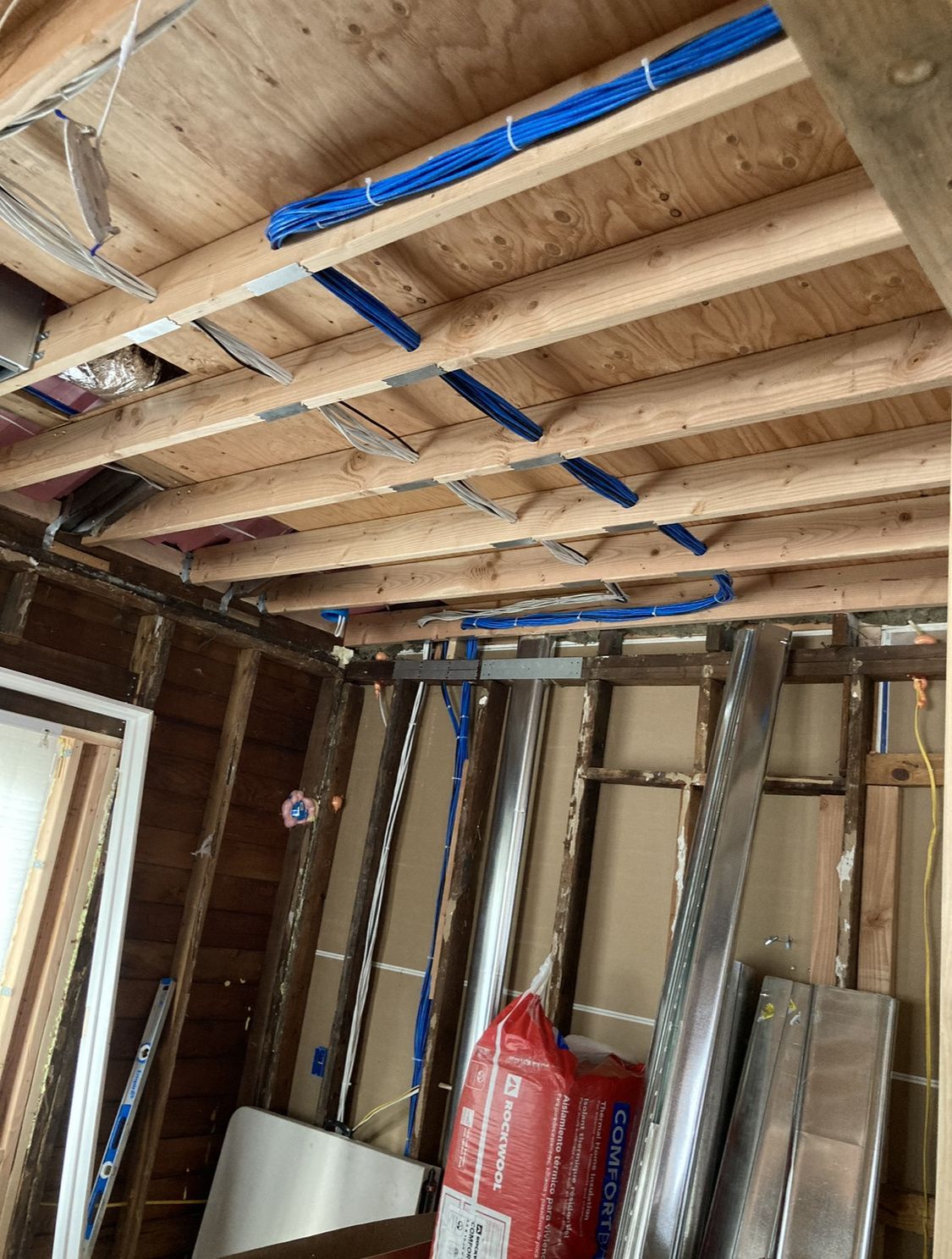 A room with a lot of wooden beams and a bag of insulation.