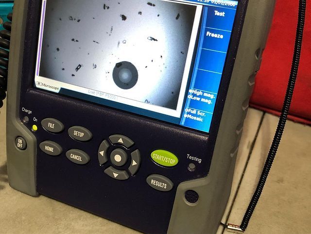 A close up of a device with a green button that says 