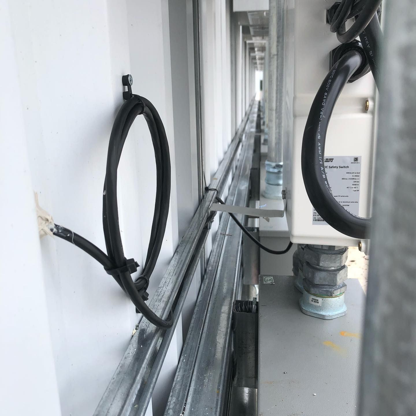 A bunch of wires are hanging on a wall