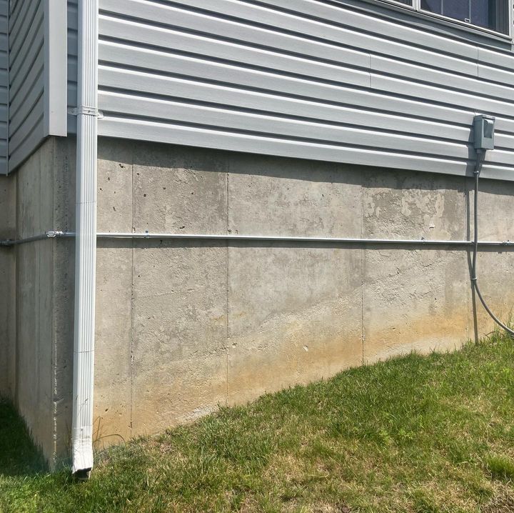 The side of a house with a drain pipe and a power outlet
