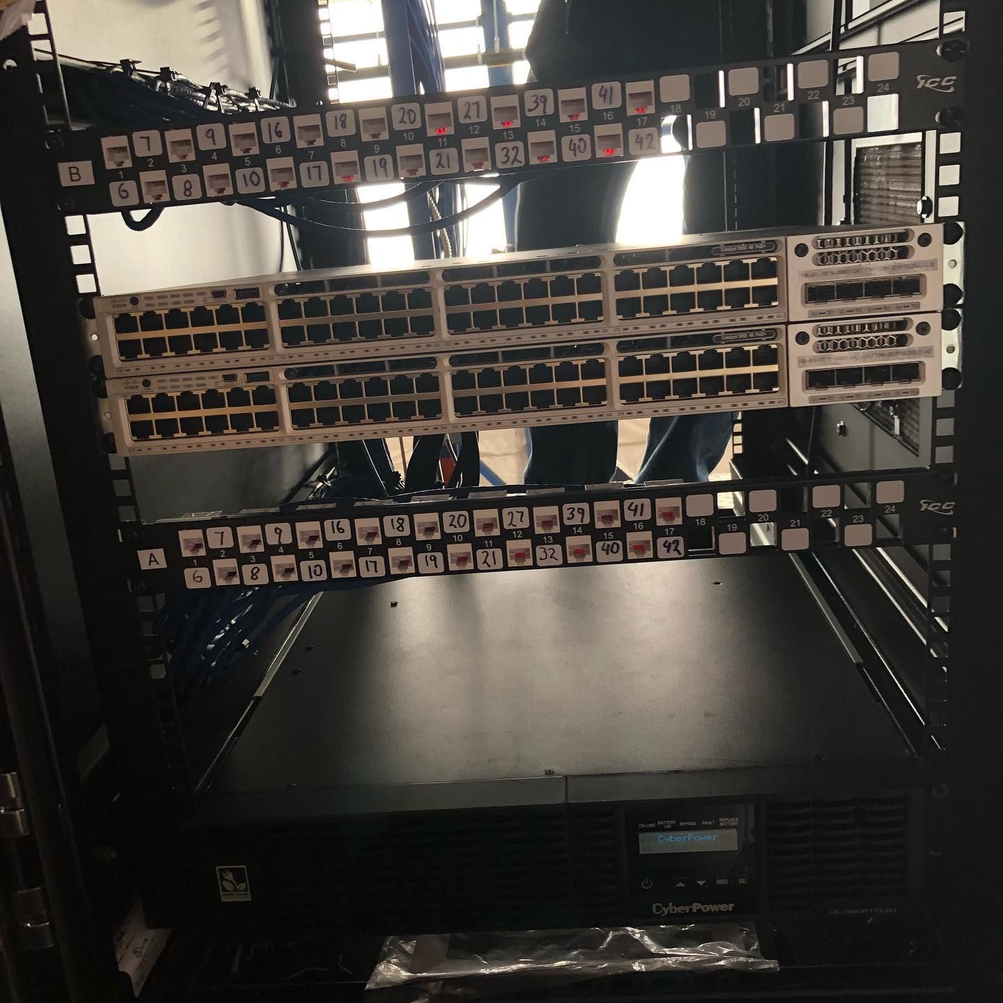 A server rack with a lot of wires hanging from it