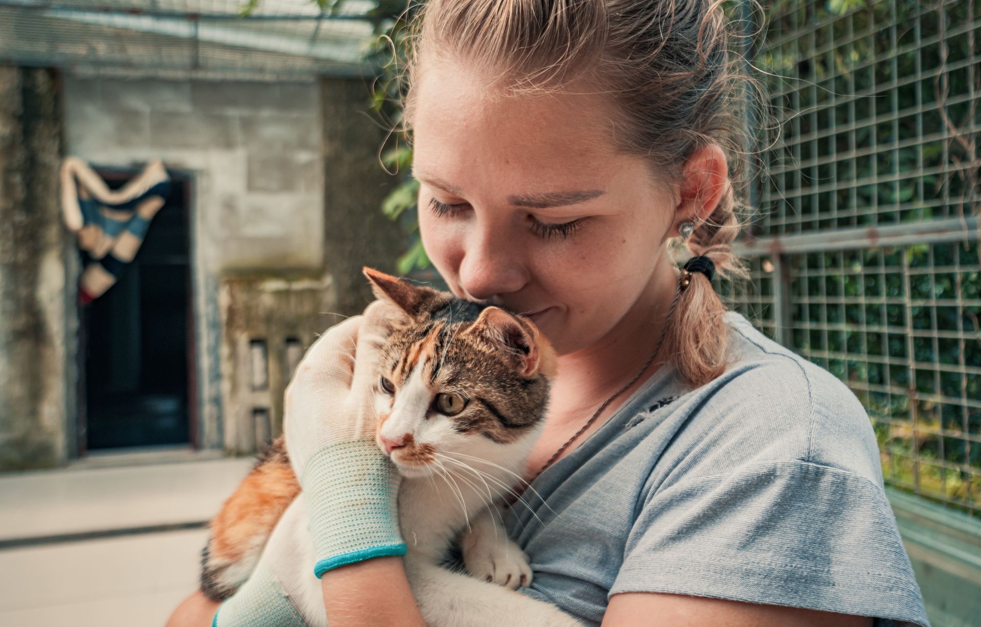 A woman is holding a cat in her arms.