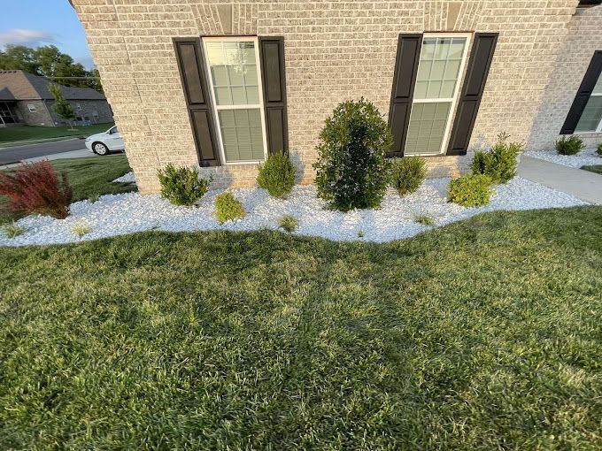 A brick house with a lush green lawn in front of it.