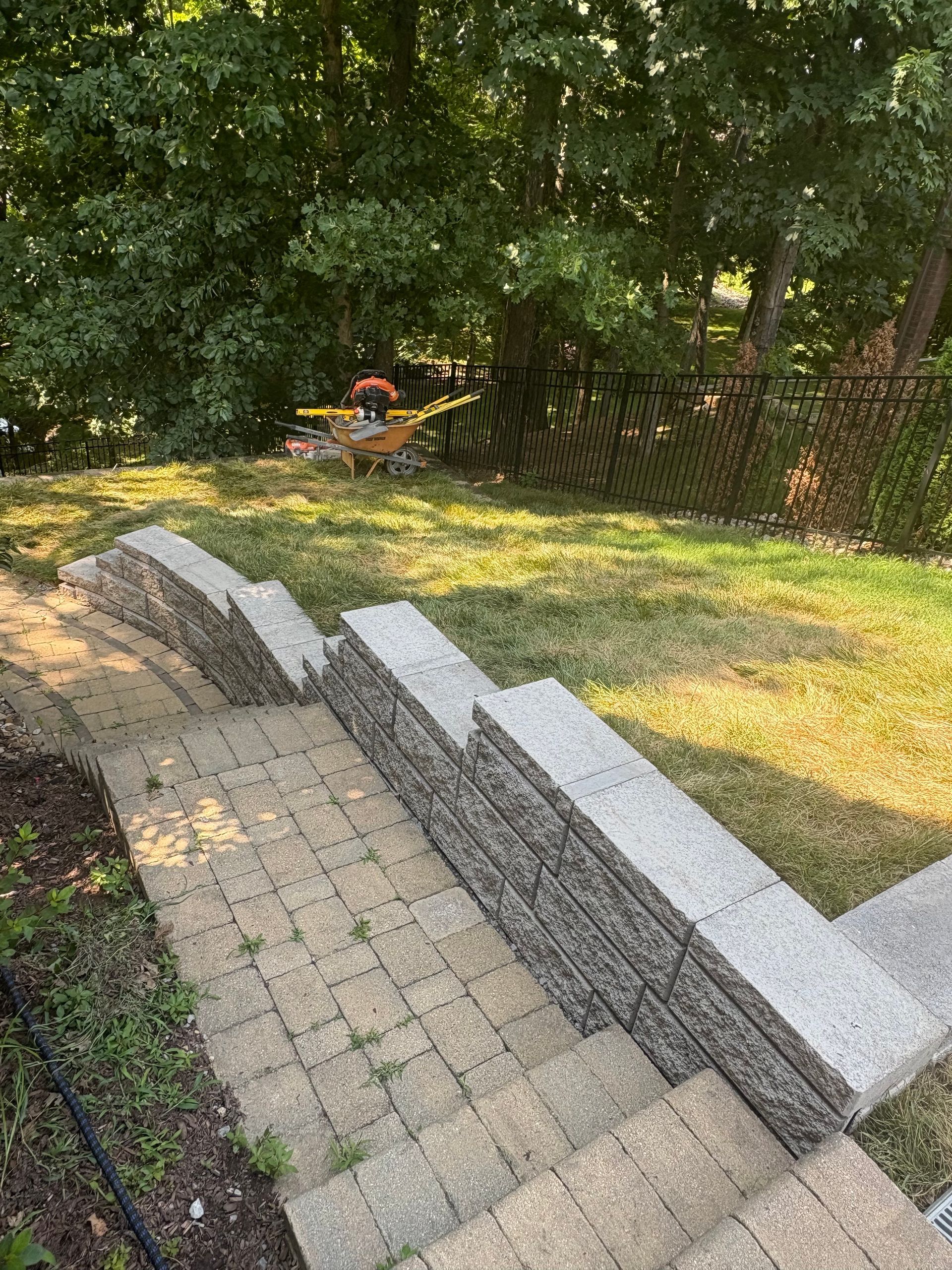 A brick walkway leading up to a lush green yard.