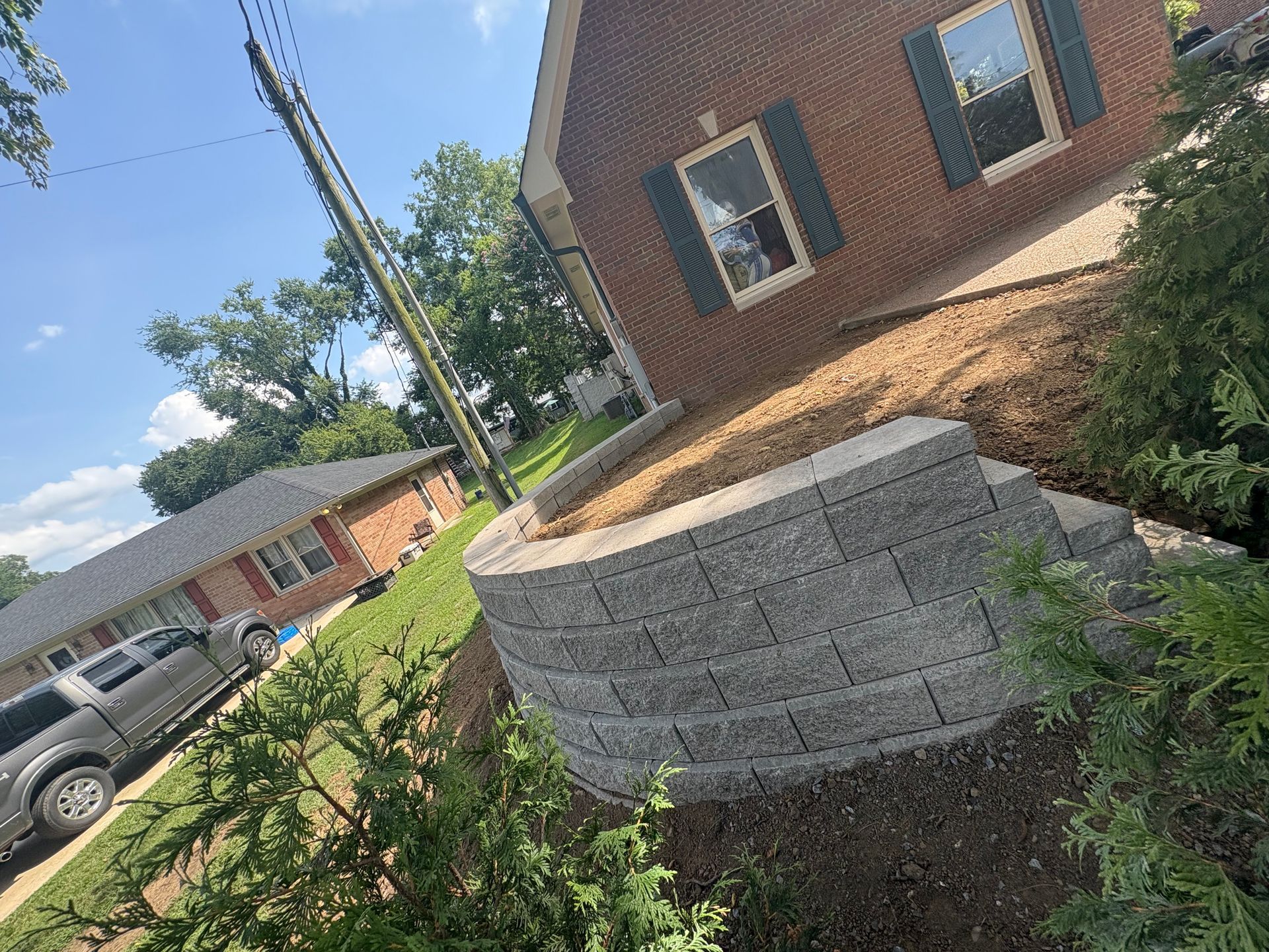 Brick house with a retaining wall and landscaping.