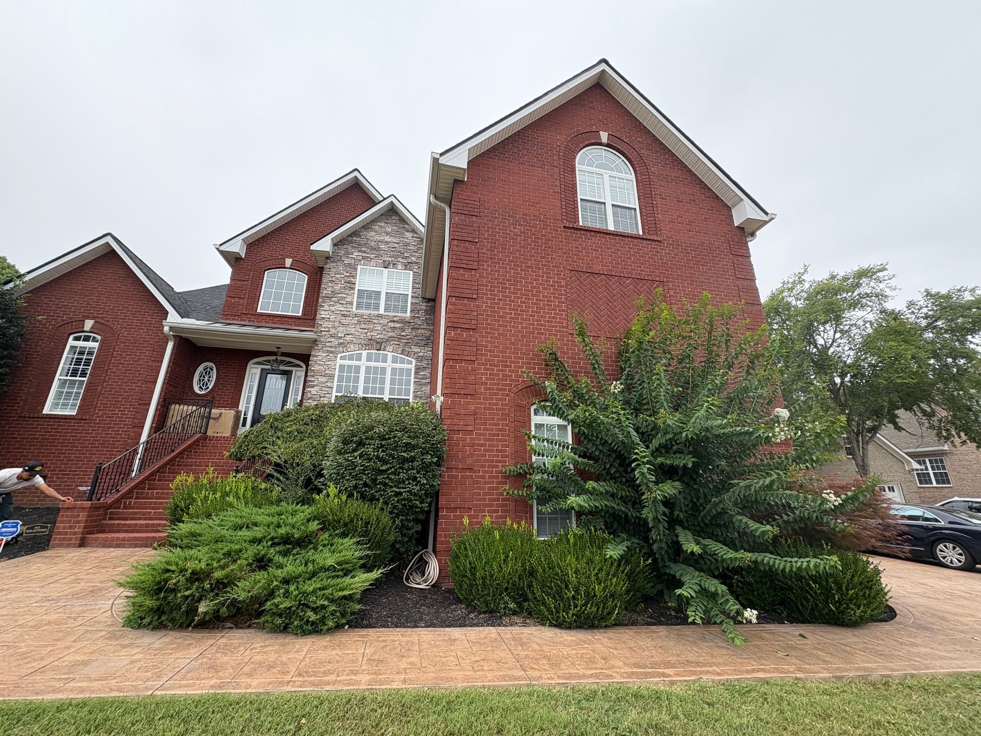A house with a lot of windows and a lawn in front of it.