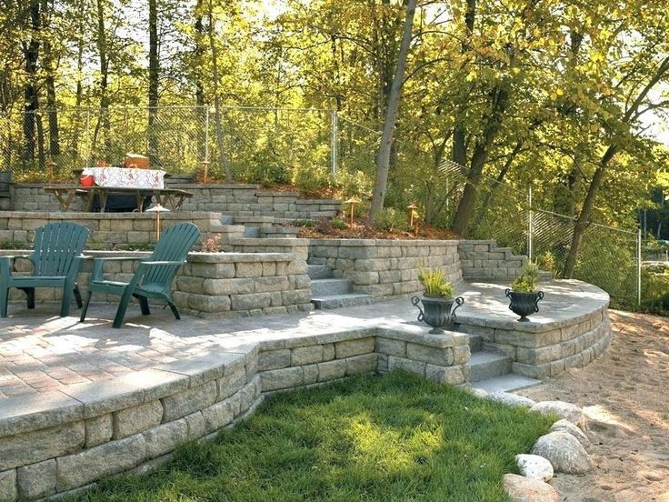 A patio with chairs and a table in the woods