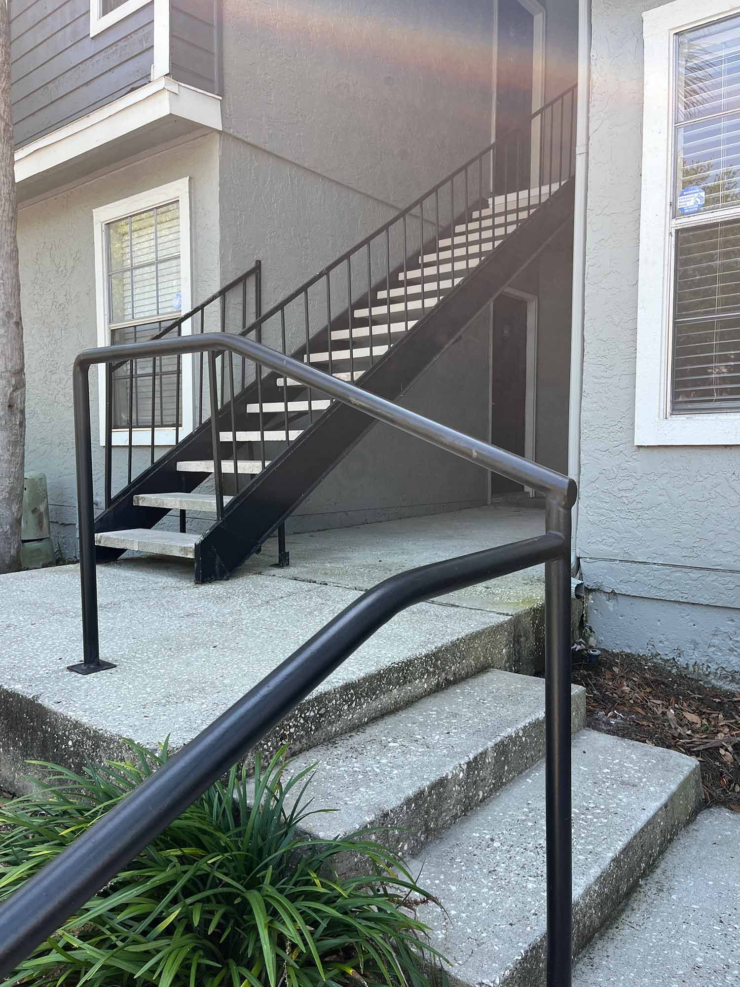 Exterior staircase with concrete steps and pipe railing