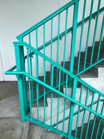 Parking garage stairs with turquoise metal handrail