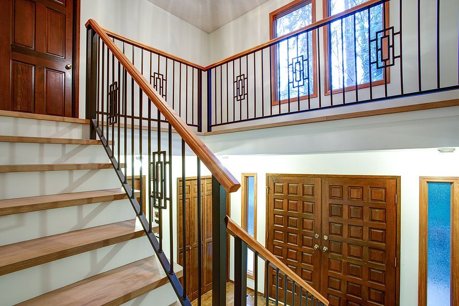 Wooden steps with banisters leading to a closed doorway