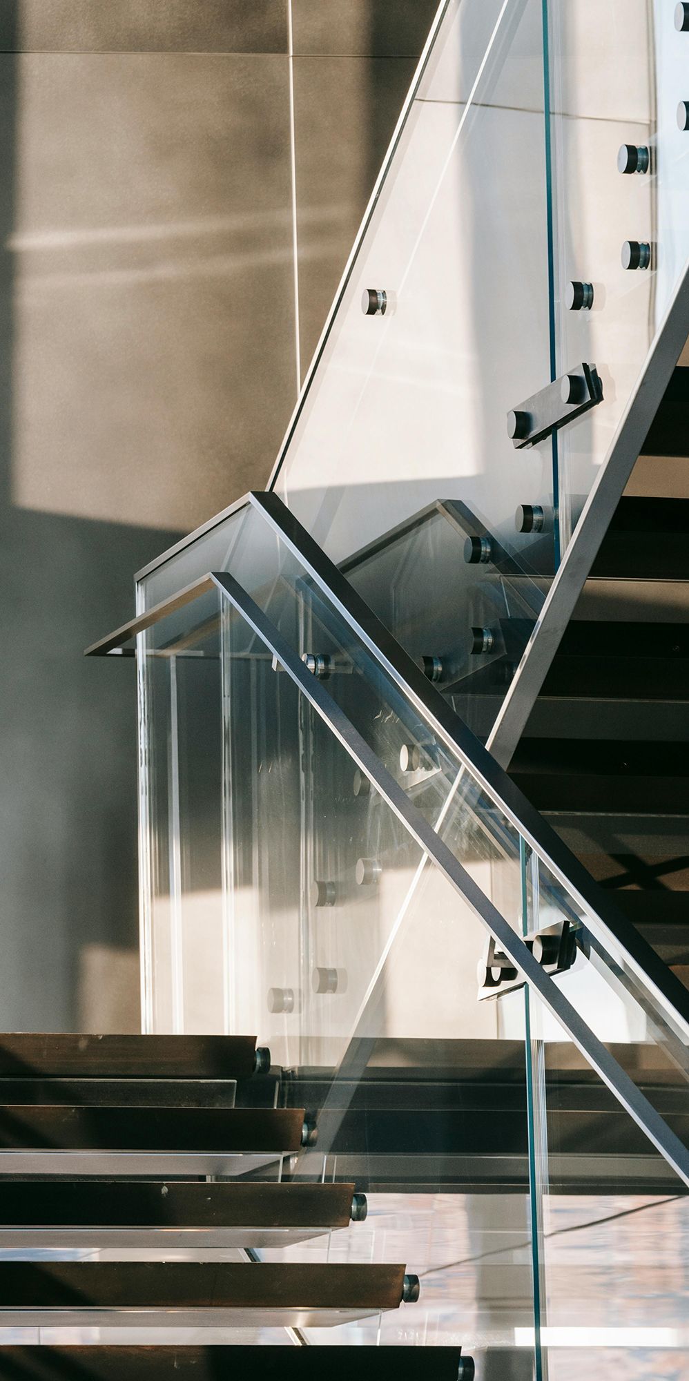 close up of glass staircase with modern metal hand rail