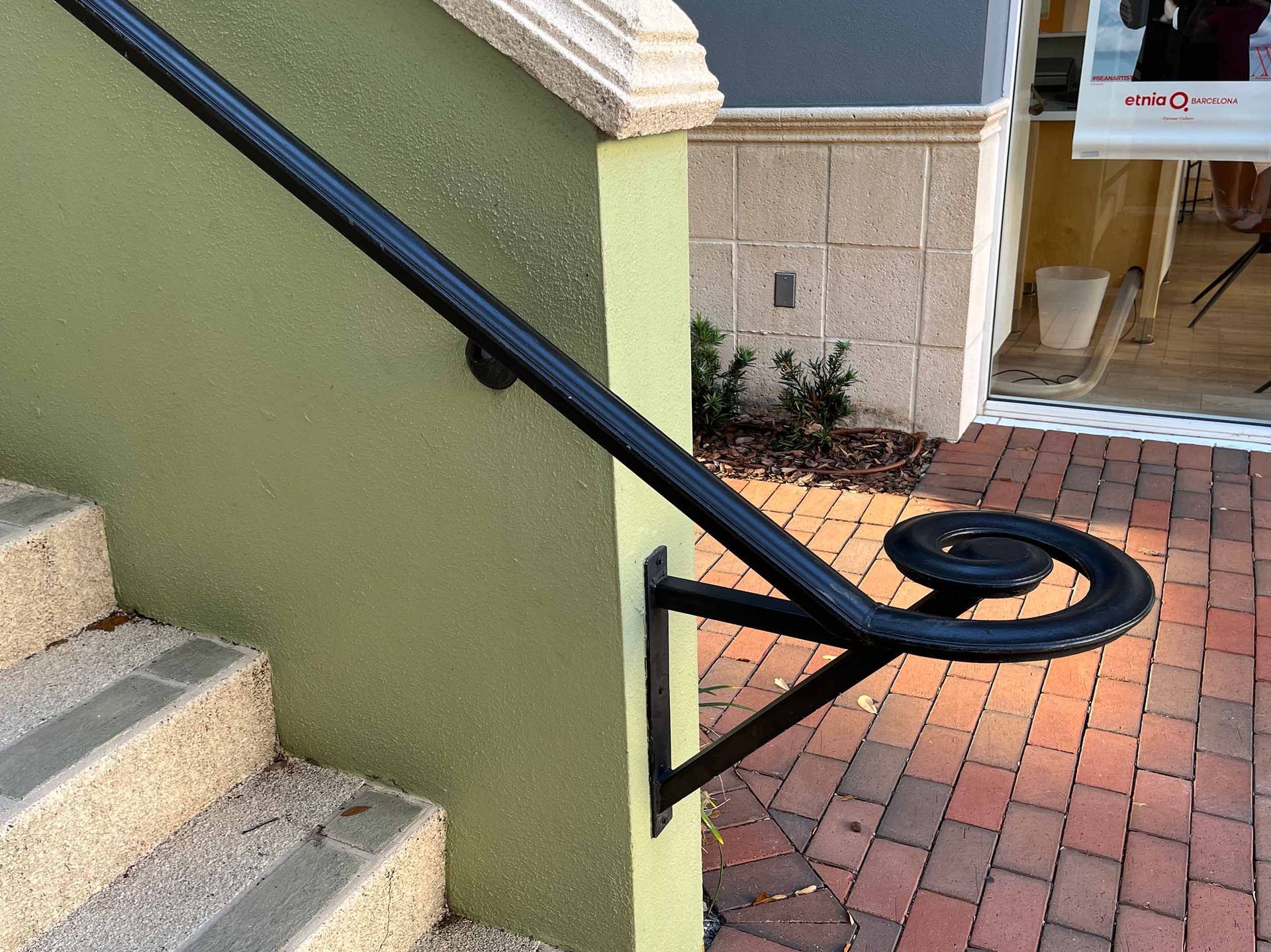 wrought iron handrail painted black and mounted next to stairs