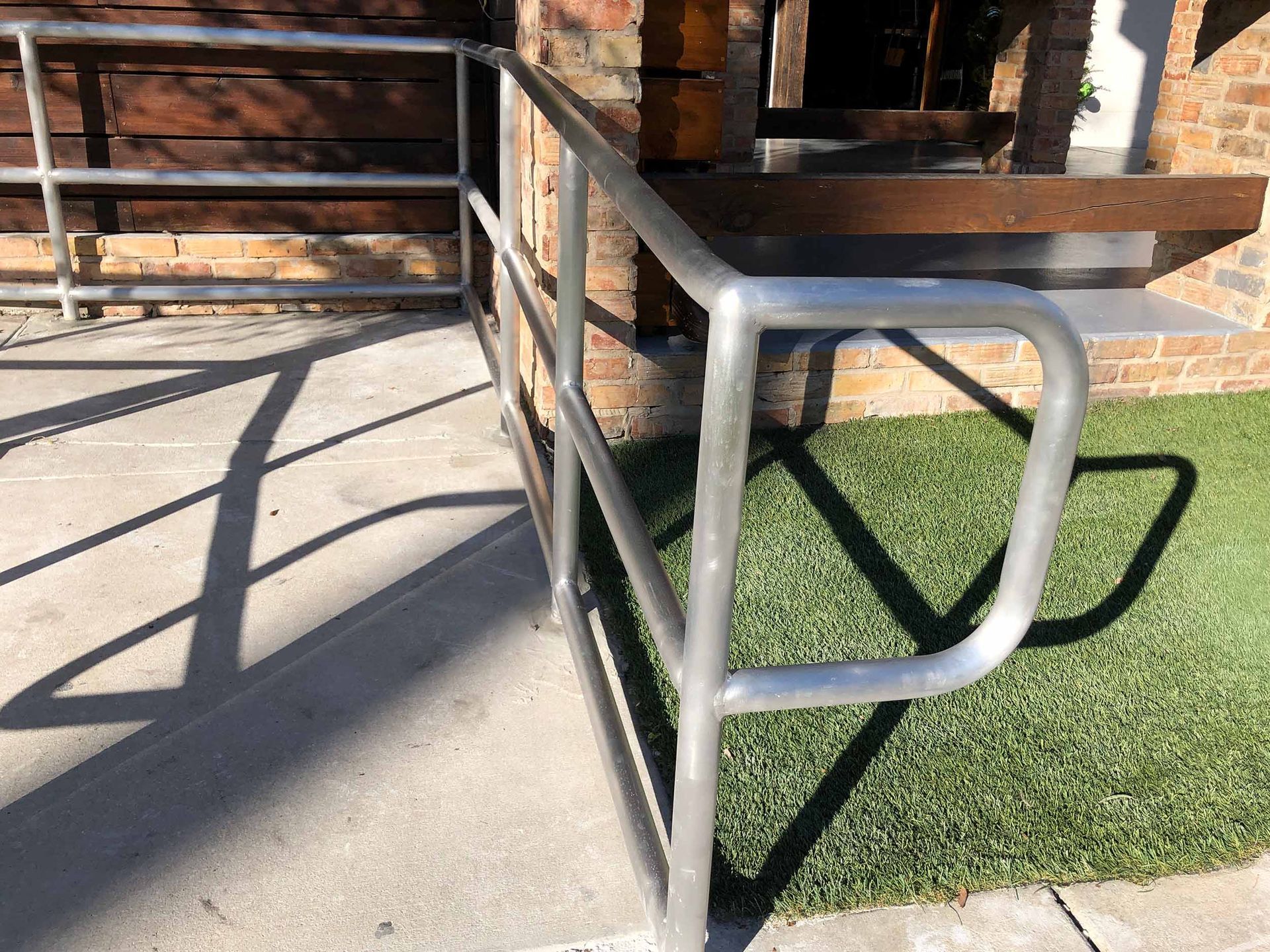 silver pipe railing welded and installed in concrete