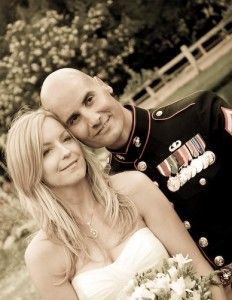 A man in a military uniform and a woman in a wedding dress are posing for a picture.