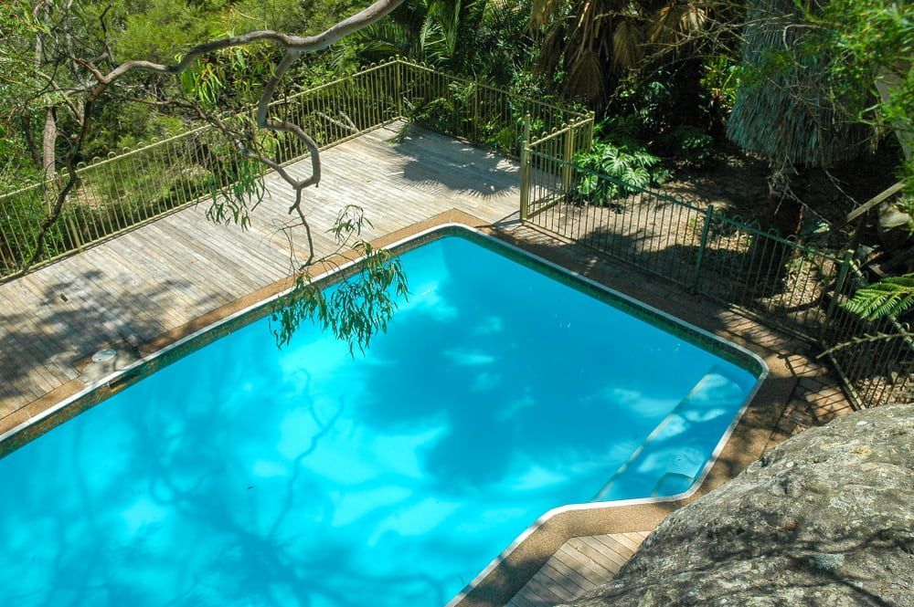 An Aerial View of A Large Swimming Pool Surrounded by Trees — Topline Aluminium Forster Pty Ltd in Harrington, NSW