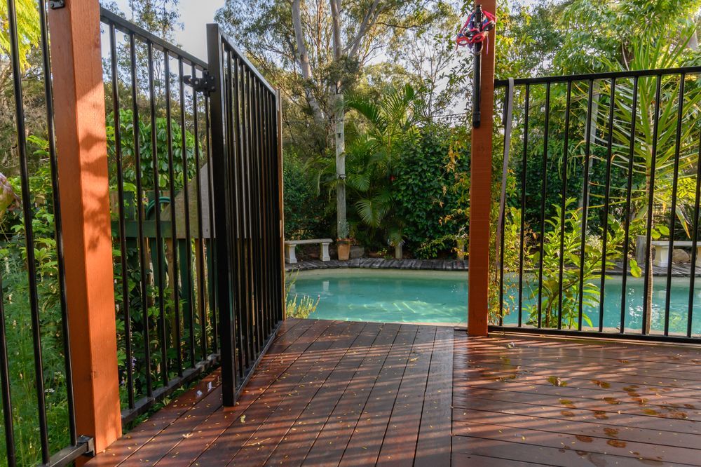A Swimming Pool Is Surrounded by A Fence and A Pergola — Topline Aluminium Forster Pty Ltd in Forster, NSW