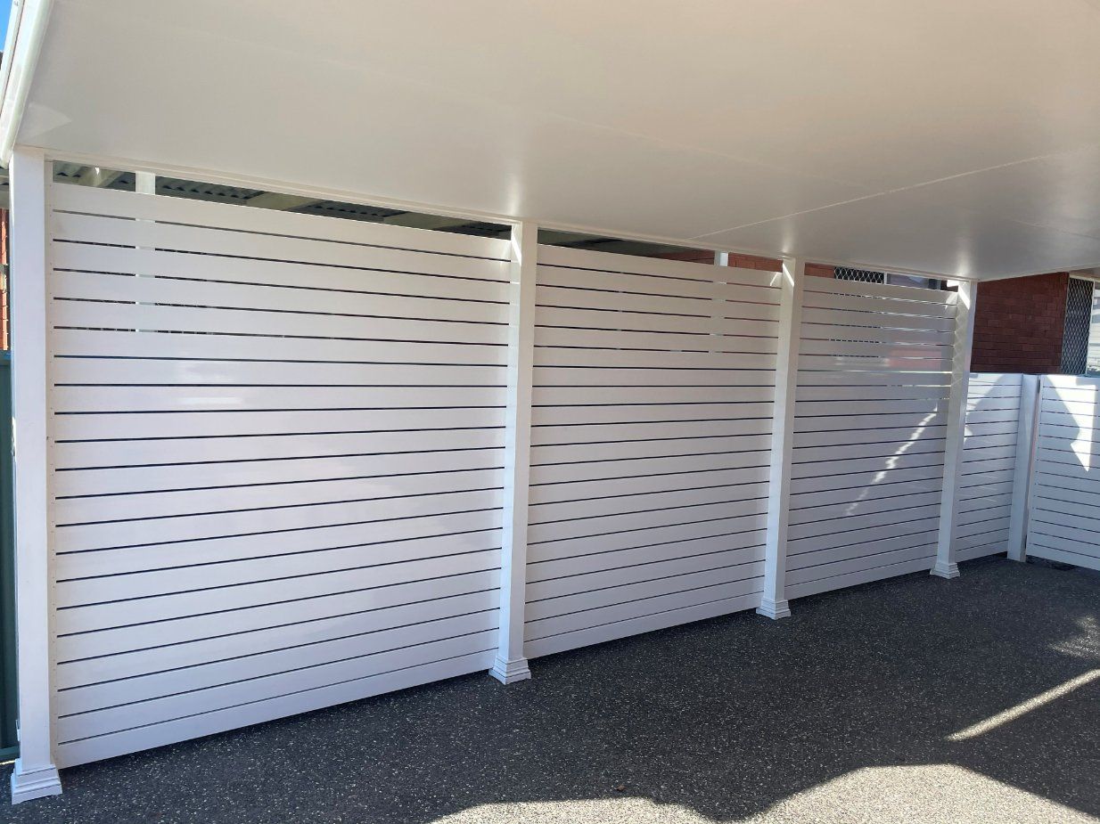 A White Fence with Holes in It Is in A Parking Lot — Topline Aluminium Forster Pty Ltd in Harrington, NSW