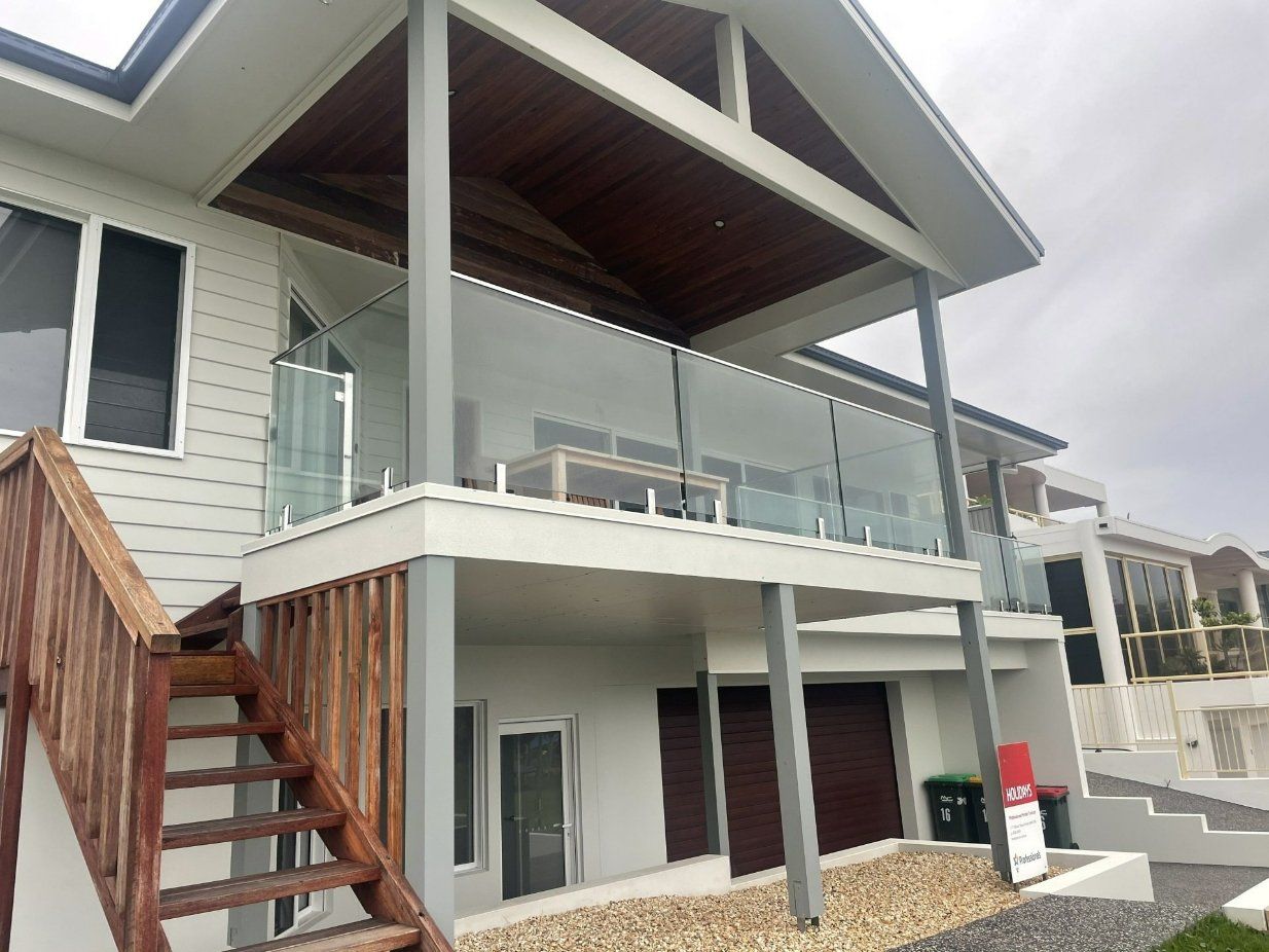 A White House with A Balcony and Stairs Leading up To It — Topline Aluminium Forster Pty Ltd in Harrington, NSW