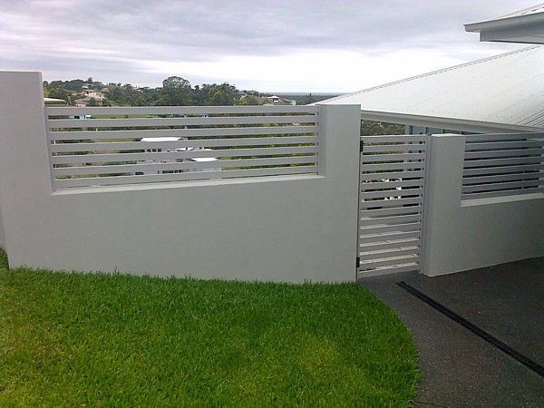 A White Fence with A Gate in The Backyard of A House — Topline Aluminium Forster Pty Ltd in Hallidays Point, NSW