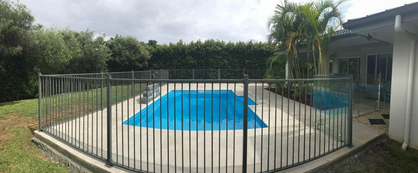A Large Swimming Pool Surrounded by A Metal Fence — Topline Aluminium Forster Pty Ltd in Smiths Lake, NSW