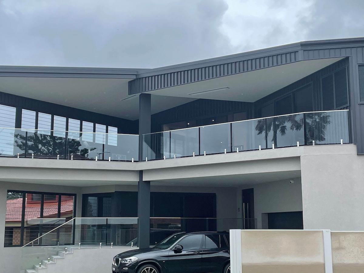 A White House with A Balcony and Stairs Leading up To It — Topline Aluminium Forster Pty Ltd in Forster, NSW