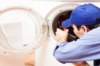 Man fixing the washing Machine's Door — Appliances Repairs in Marietta, Ohio