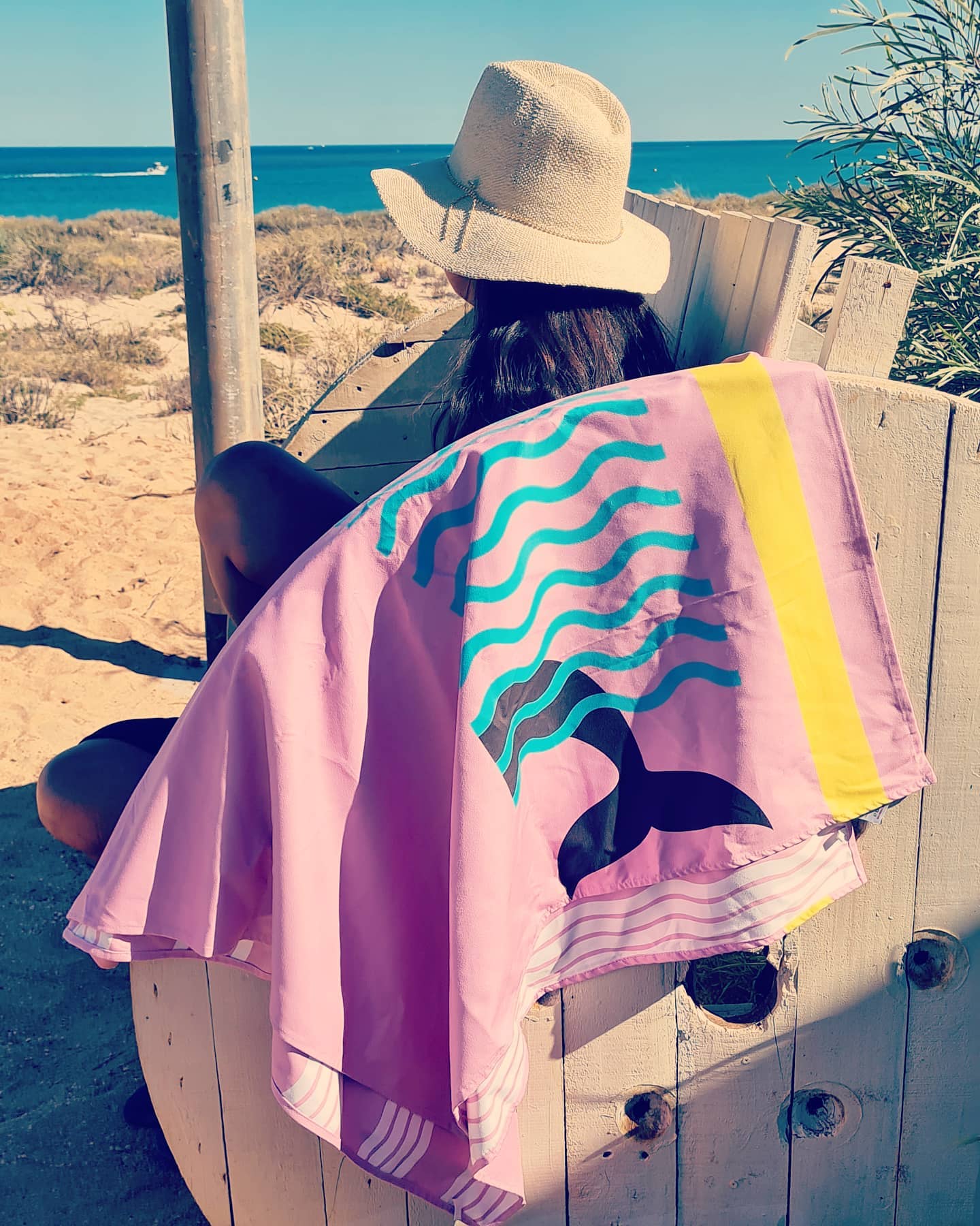 Belle & Phia towel hung over a park bench female looking out to sea