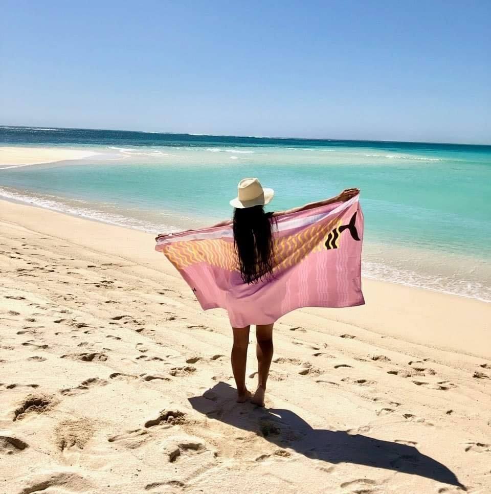 Massive Belle & Phia towel held up on the beach
