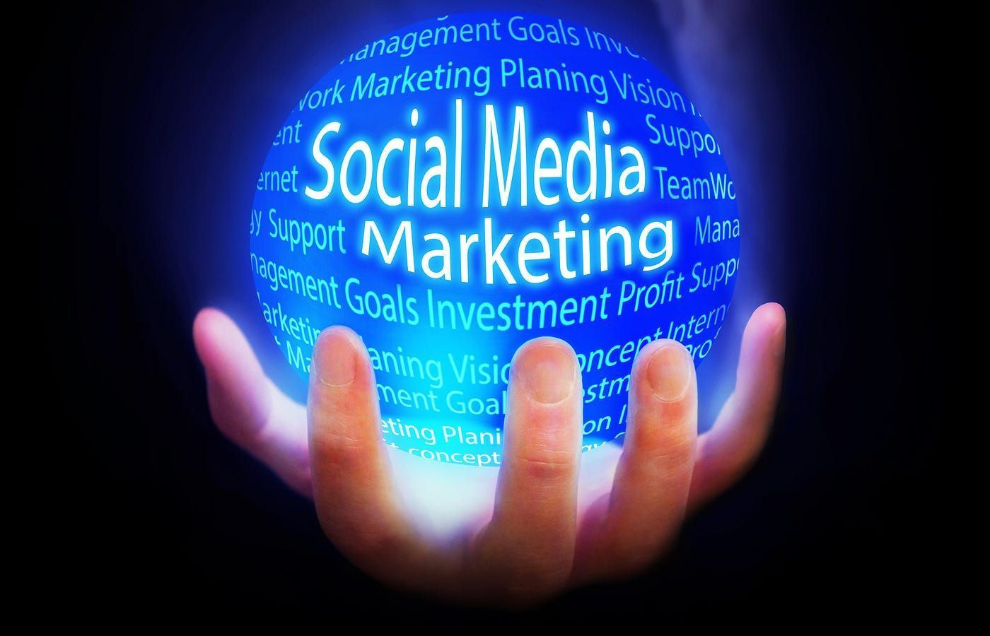 A hand is holding a sphere that says social media marketing