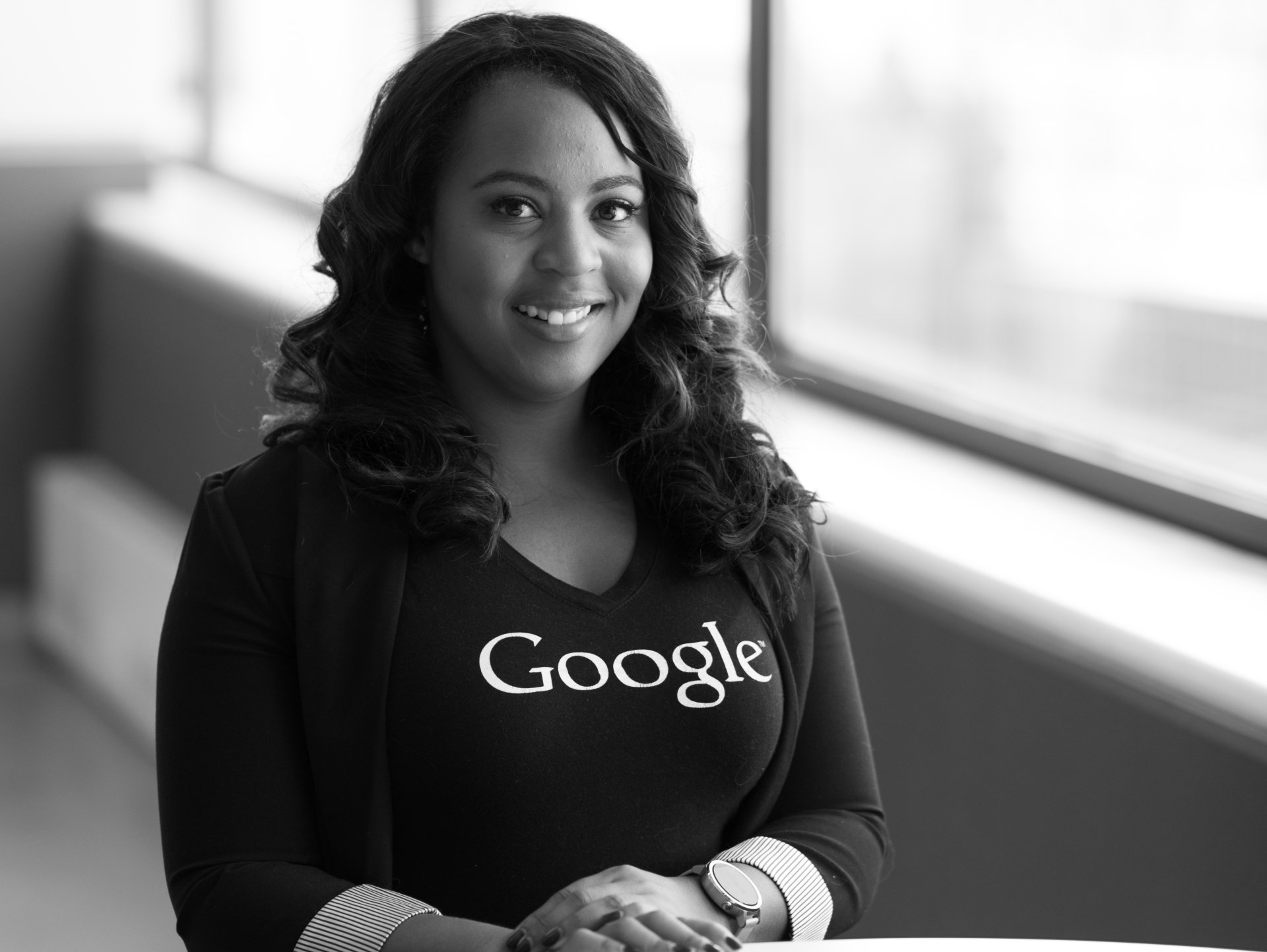 A black and white photo of a woman wearing a google shirt