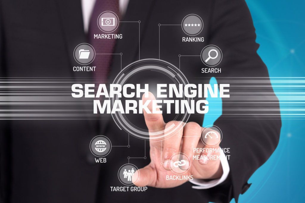 A man in a suit and tie is pressing a button that says search engine marketing.