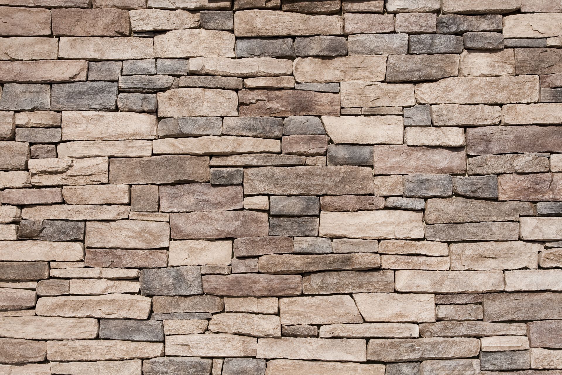 A close up of a stone wall with a brick pattern