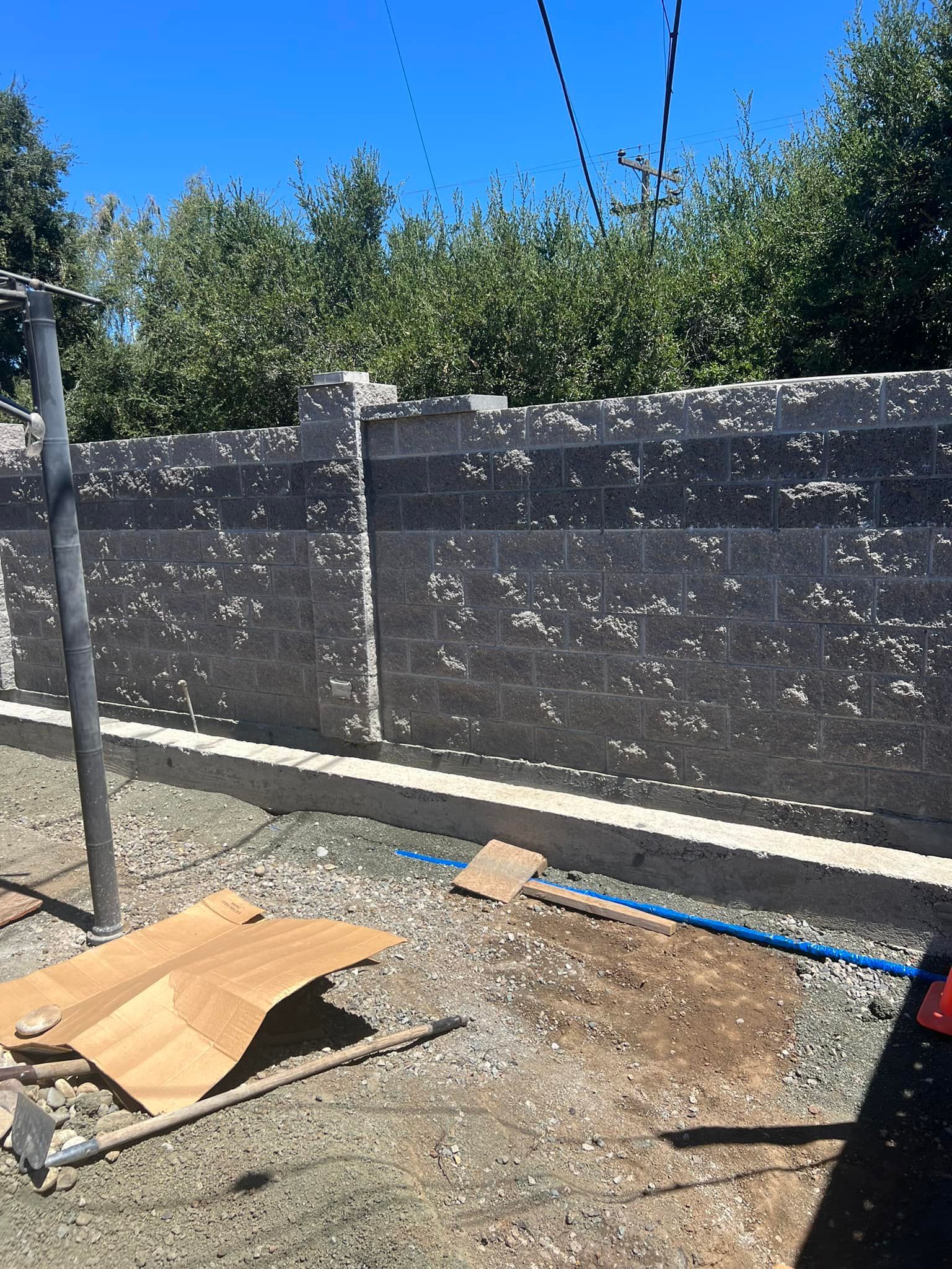 A brick wall is being built in a backyard