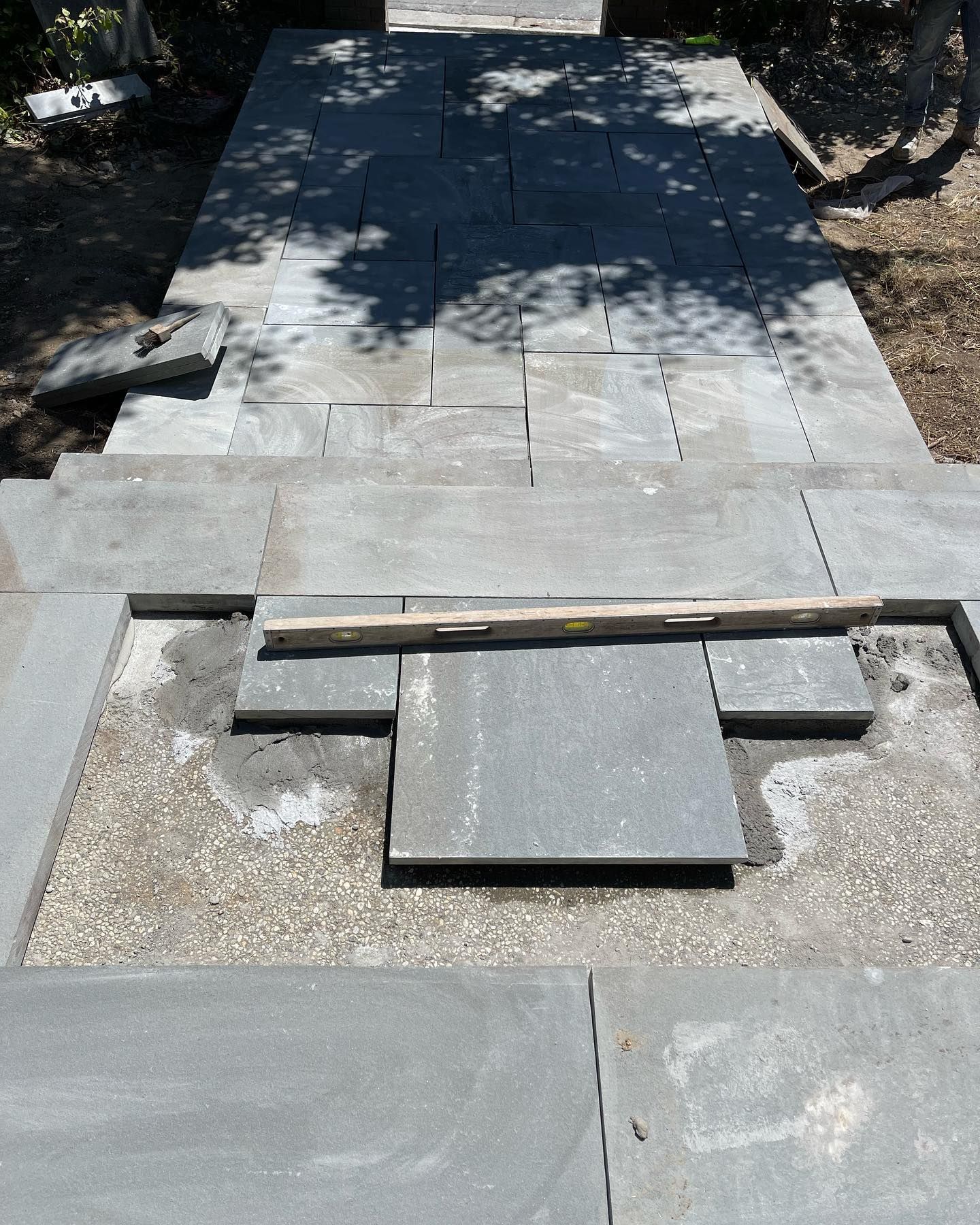 A concrete walkway is being built in a backyard