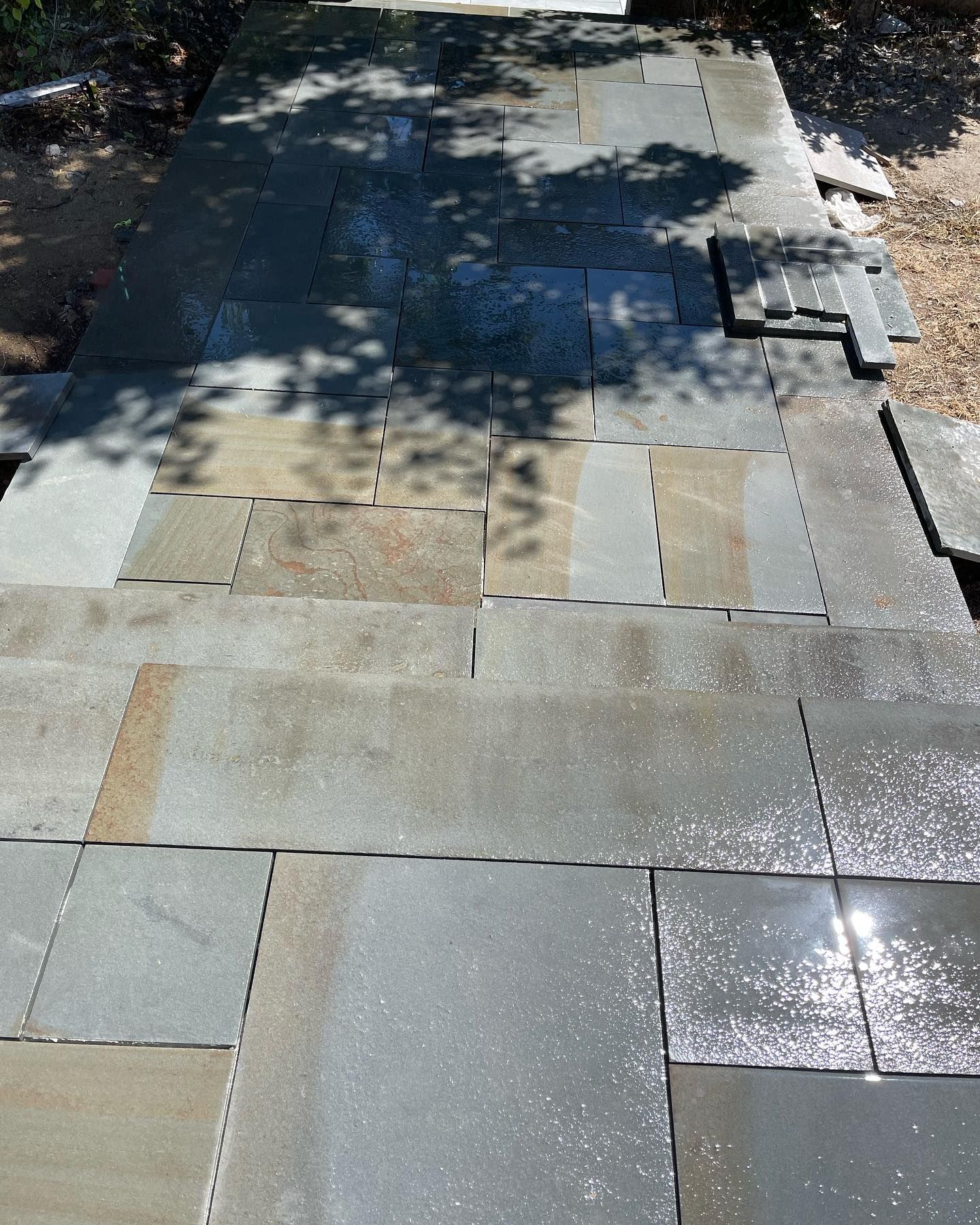 A stone walkway with a tree shadow on it