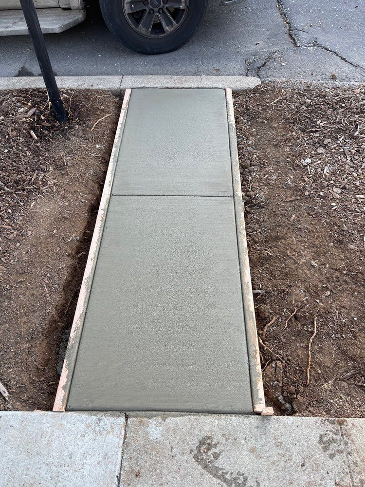 A concrete sidewalk is being built next to a car.